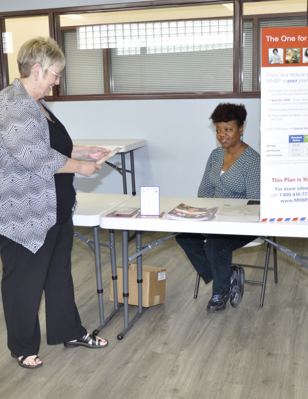 Cheri Magorno, multimedia specialist, asks questions of the Mail Handlers Benefits Program representative, Kitty McNeil, at the Benefits Fair held aboard Marine Corps Logistics Base Barstow, Calif., Oct. 28