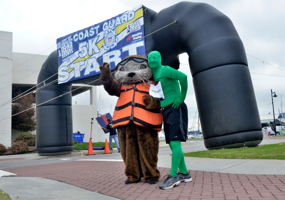 Sammy the Sea Otter and Green Man pose during Coast Guard Day 5k