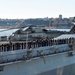Sailors and Marines man the rails as the amphibious landing dock ship USS New York (LPD 21) pulls into port