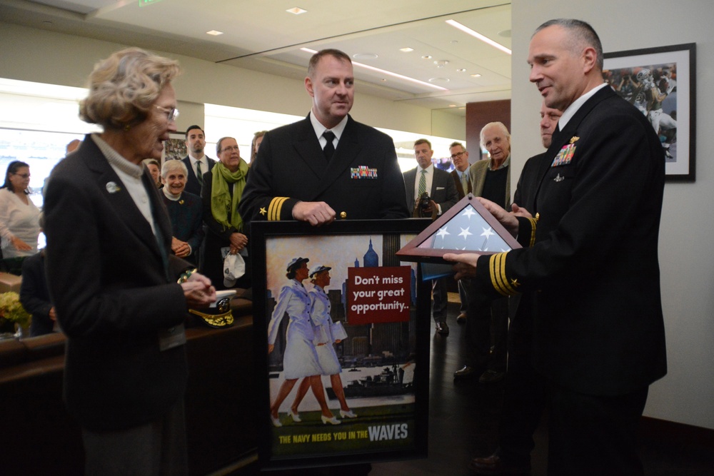 Cmdr. Tony Grayson, commanding officer of the USS Providence (SSN 719) presents Betty Johnson a national ensign flown in her honor