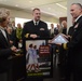 Cmdr. Tony Grayson, commanding officer of the USS Providence (SSN 719) presents Betty Johnson a national ensign flown in her honor