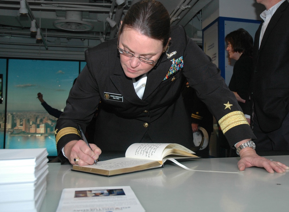 Rear Adm. Cynthia M. Thebaud, commander Expeditionary Strike Group 2, signs the guest book at the National Sept. 11 Memorial and Museum