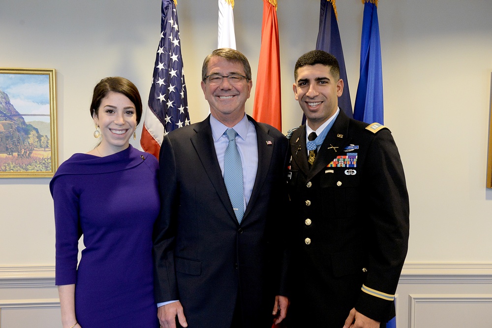 Secretary of defense takes a photo with retired Army Capt. Florent Groberg and his wife before the Medal of Honor Hall of Heroes induction ceremony