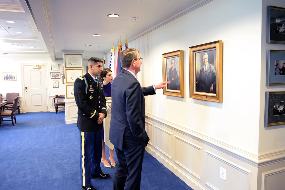 Secretary of defense speaks with retired Army Capt. Florent Groberg and his wife in his office before the Medal of Honor Hall of Heroes induction ceremony