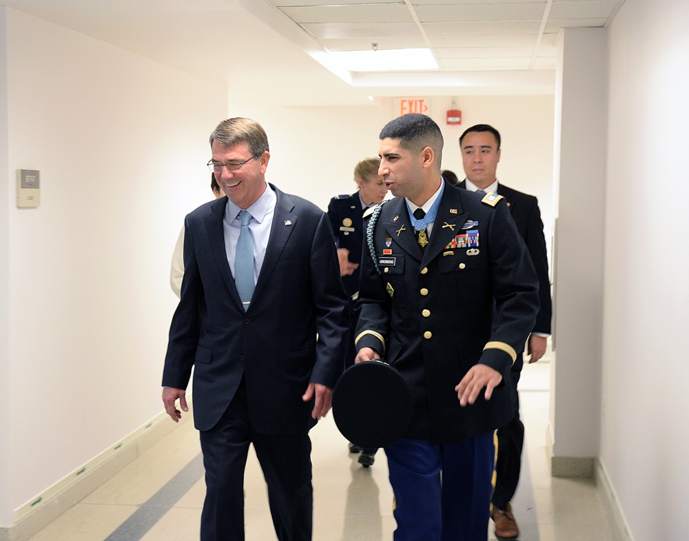 Secretary of defense walks and talks with retired Army Capt. Florent Groberg on the way to the Medal of Honor Hall of Heroes induction ceremony