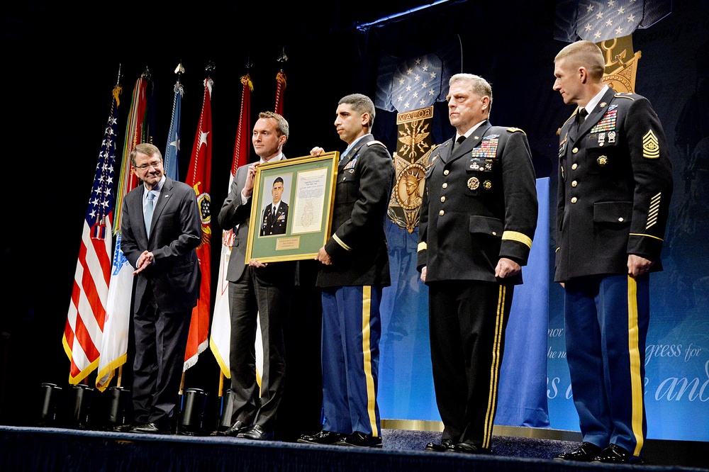 SD, SAC, COS and SMA look on as retired Army Capt. Florent Groberg accepts a plaque during the Medal of Honor Hall of Heroes induction ceremony