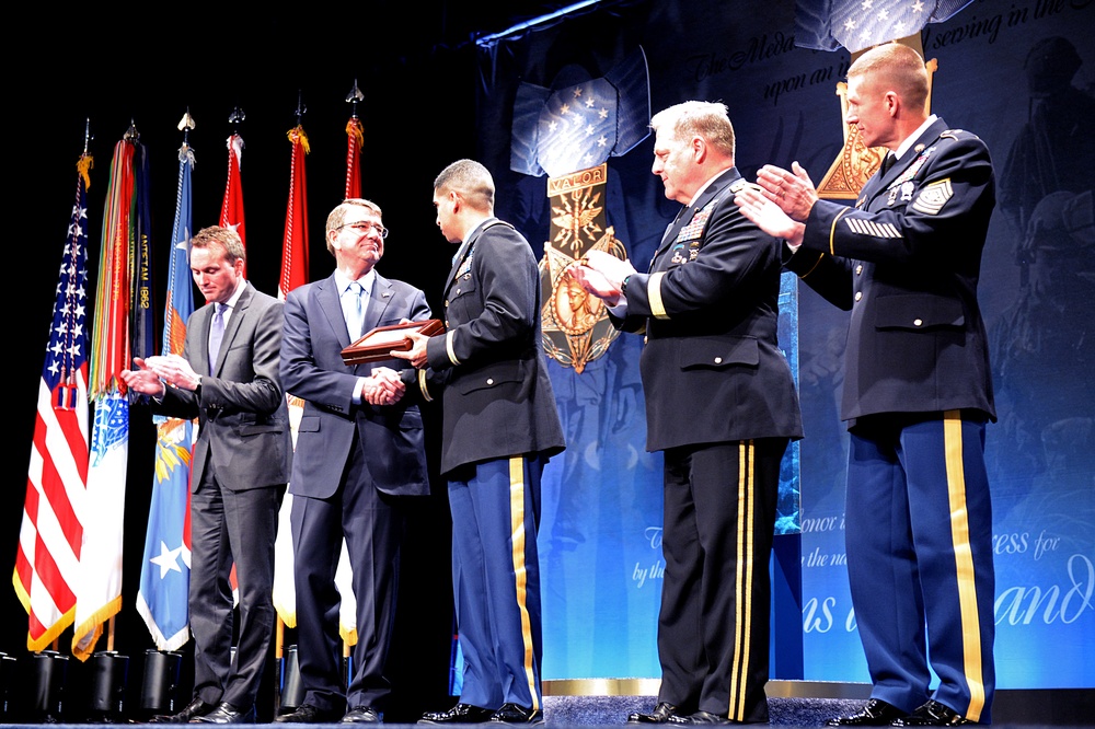 Secretary of defense congratulates retired Army Capt. Florent Groberg as he accepts a plaque