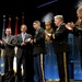 Secretary of defense presents retired Army Capt. Florent Groberg with a flag during the Medal of Honor Hall of Heroes induction ceremony