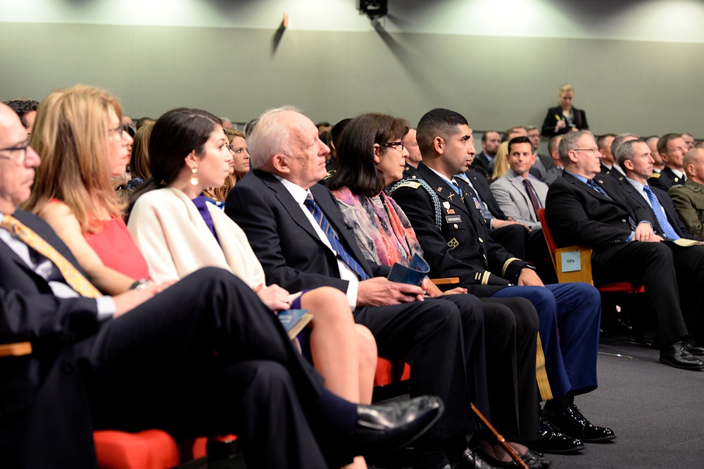 Retired Army Capt. Florent Groberg listens to the secretary of defense speak during his Medal of Honor Hall of Heroes induction ceremony