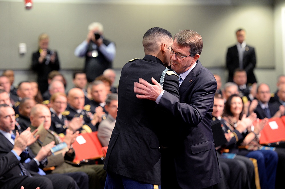 Secretary of defense shares an embrace with retired Army Capt. Florent Groberg after he spoke at the Medal of Honor Hall of Heroes induction ceremony