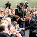 Secretary of defense shakes hands with retired Army Capt. Florent Groberg's family members at the Medal of Honor Hall of Heroes induction ceremony