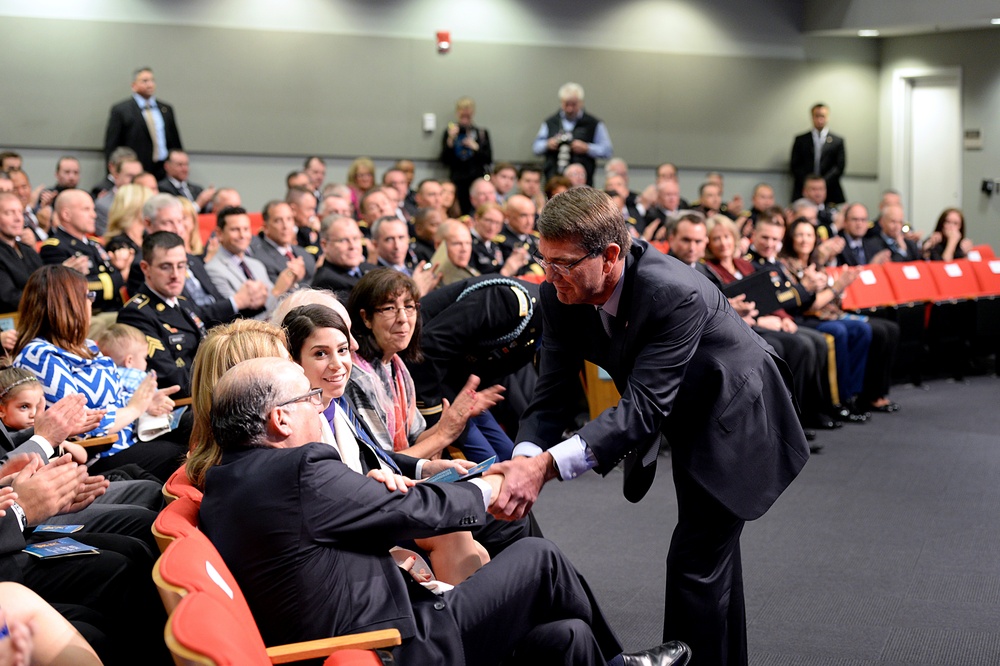 Secretary of Defense shakes hands with retired Army Capt. Florent Groberg's family members at the Medal of Honor Hall of Heroes induction ceremony