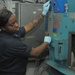 USS George Washington Sailor operates an industrial laundry machine