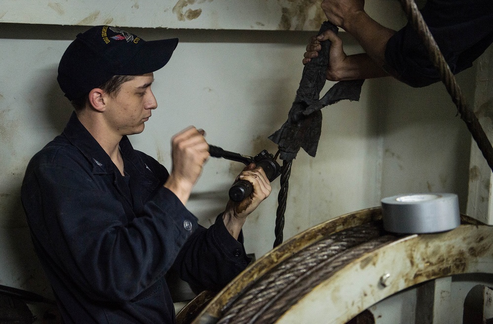 USS George Washington Sailor repairs a door wire