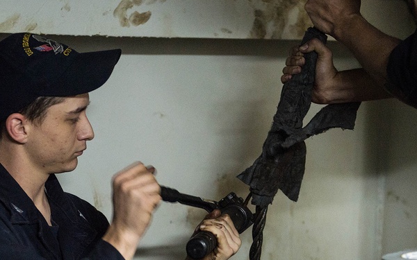 USS George Washington Sailor repairs a door wire