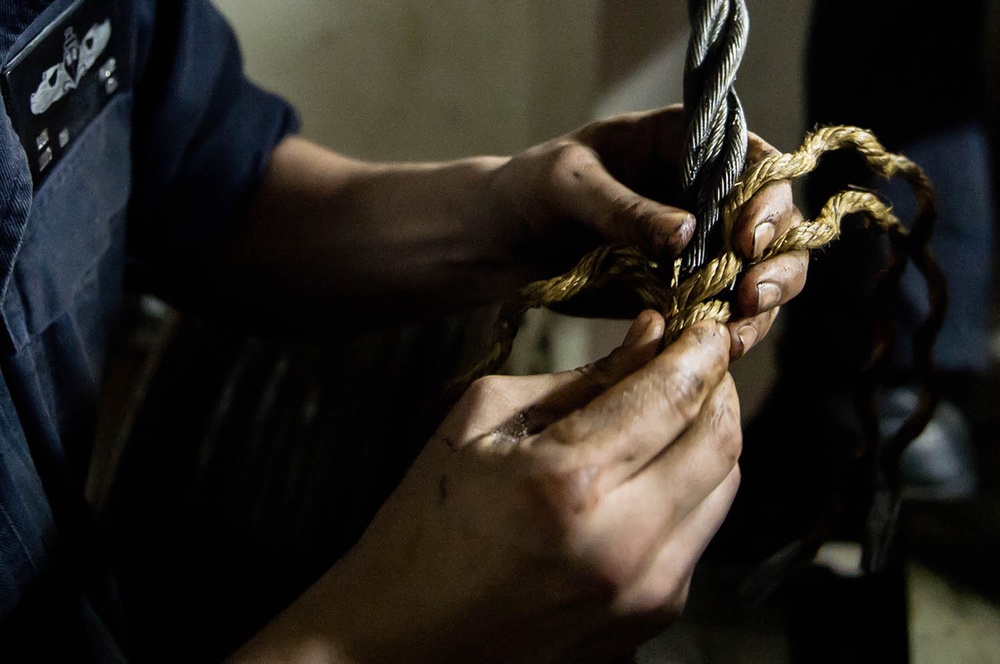 USS George Washington Sailor repairs a door wire