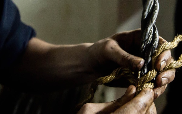 USS George Washington Sailor repairs a door wire