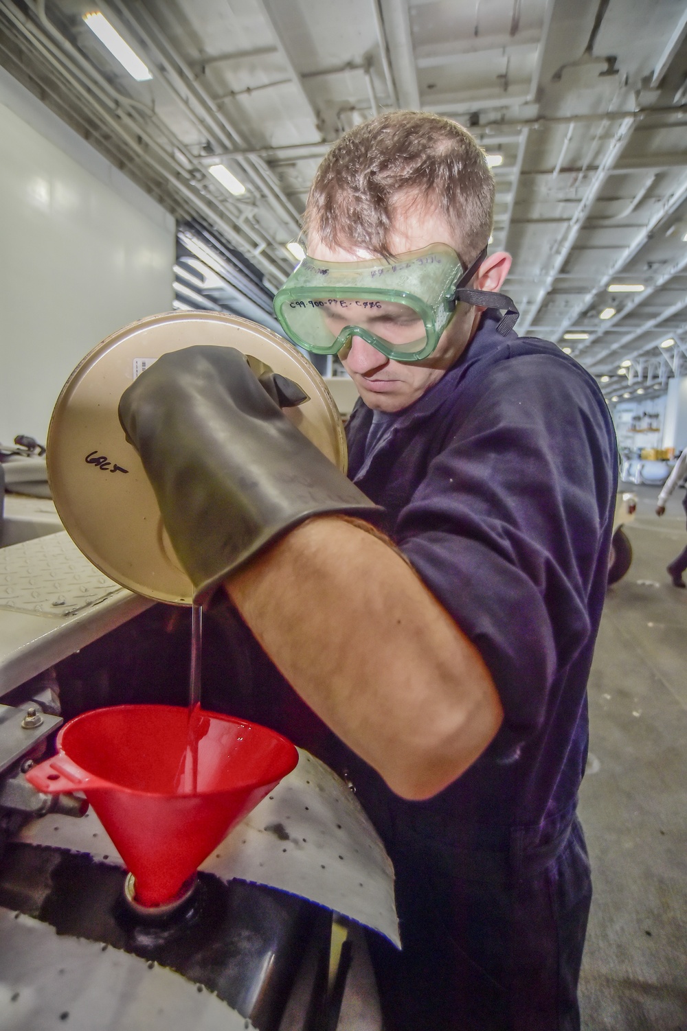 USS Dwight D. Eisenhower Sailor adds hydraulic fluid into flight deck scrubber