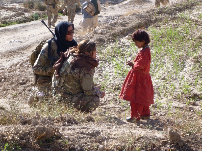 Female CST-2 member speaks with Afghan child