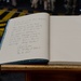 Secretary of defense signs the guestbook aboard the flagship of the French Navy, the Charles De Gaulle