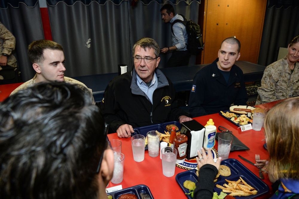 Secretary of defense speaks with Sailors and Marines during his visit on the mess decks aboard the amphibious assault ship USS Kearsarge