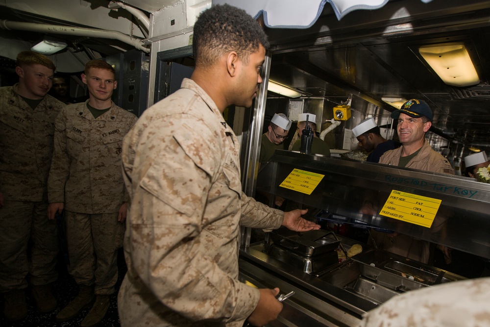 U.S. Marines and Sailors with the 26th MEU and USS Kearsarge share a Christmas meal