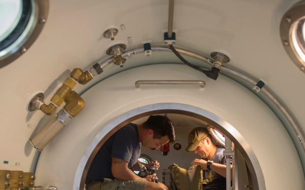 Navy divers inspect medical kit