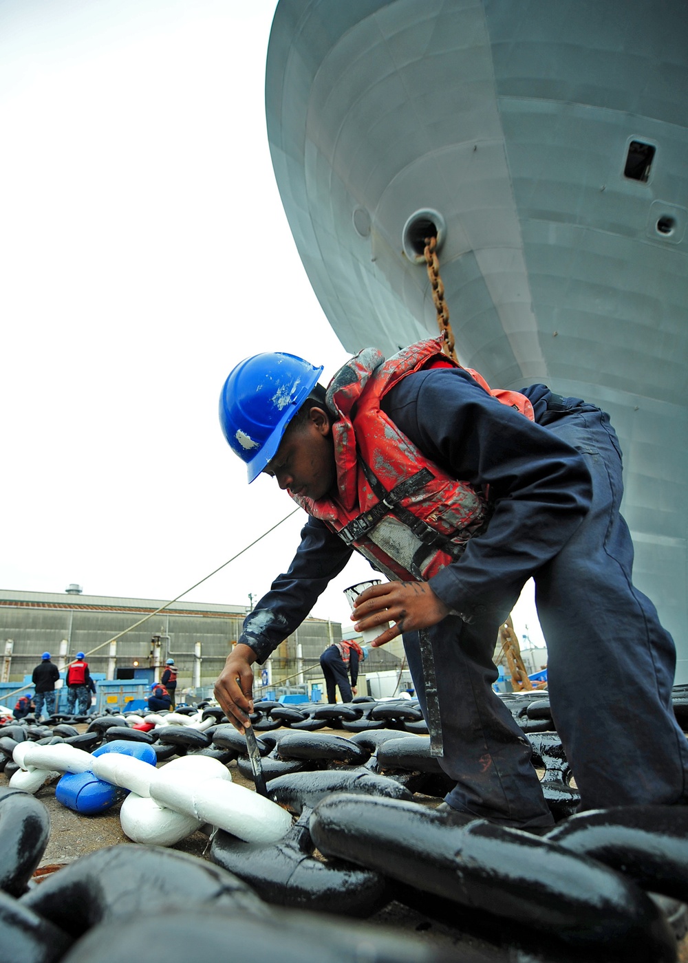 USS Blue Ridge sailor touches up anchor chain paint