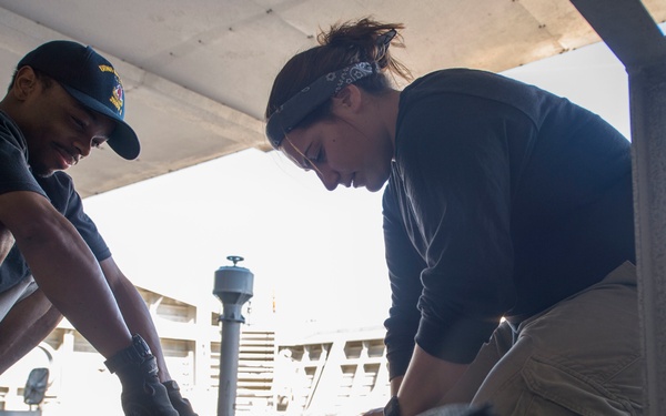 Sailors maintain mooring line aboard USNS Spearhead