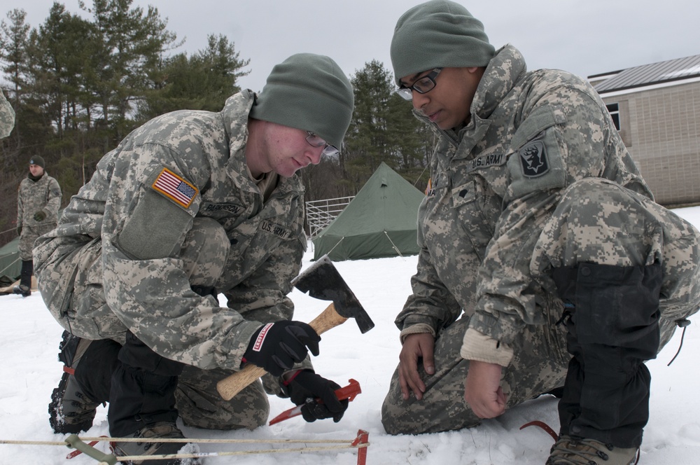 Soldiers hammer in tent stakes