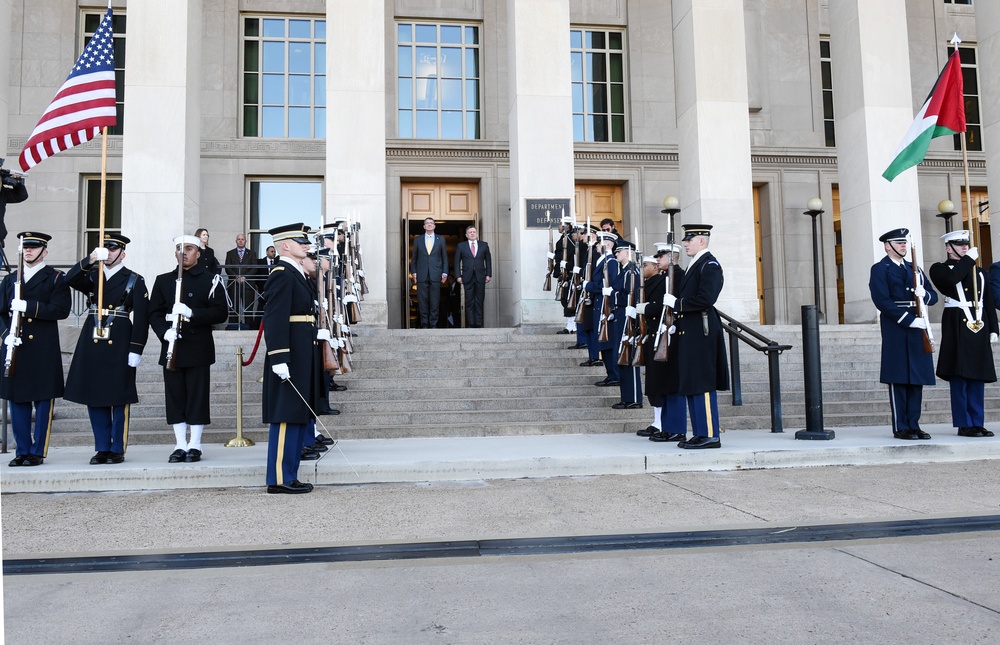Secretary of defense and Jordan's King Abdullah stand at attention before the playing of the national anthem at the Pentagon