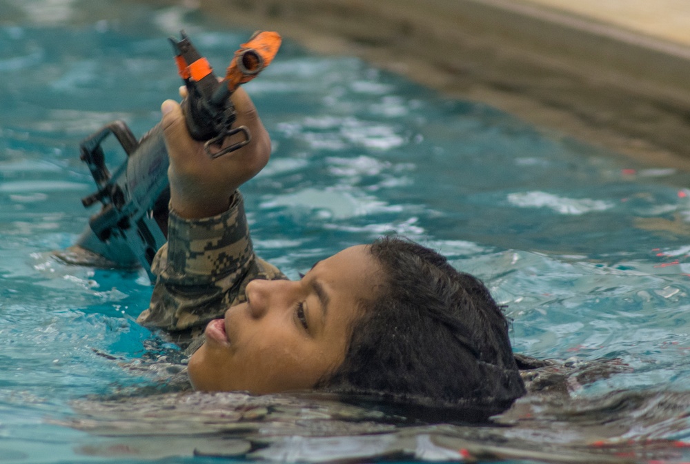 Female cadet swims with M16
