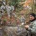 Military mountaineering students build rope bridge
