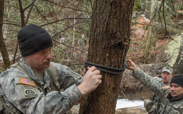 US Army military mountaineering students build rope bridge