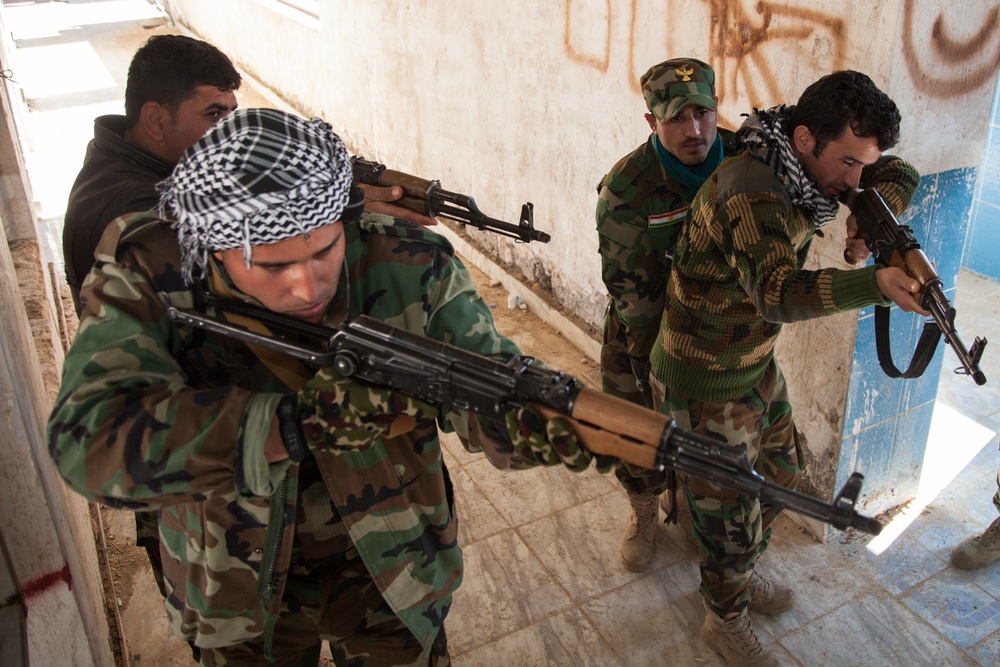 Peshmerga soldiers practice clearing a building under the supervision of German trainers