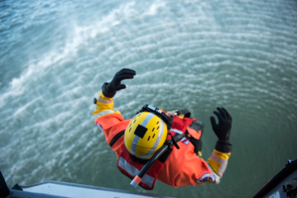 Petty Officer 3rd Class Robert Santoyo descends into the San Francisco Bay