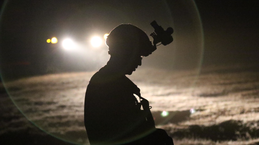 Paratrooper prepares night helo landing zone