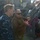 USNS Wheeler Performs Demonstration, Holds Tour for Military Officials Two military personnel are engaged in conversation on the deck of a naval vessel. One individual is wearing a Navy Working Uniform (NWU) blue digital camouflage, while the other is wearing an olive/tan fleece jacket with Navy trousers. They appear to be discussing or inspecting deck equipment, specifically a pink/magenta-colored mechanical winch or mooring apparatus.