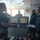 USNS Wheeler Performs Demonstration, Holds Tour for Military Officials The image shows what appears to be a ship's bridge or command center where a civilian is briefing two U.S. Navy personnel in digital camouflage uniforms. Several navigation and monitoring screens are visible on the console, and additional personnel are present in the background. The setting suggests an official tour or operational briefing aboard a vessel.
