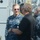 USNS Wheeler Performs Demonstration, Holds Tour for Military Officials The image shows a group of individuals on what appears to be the deck of a U.S. Navy vessel. A U.S. Navy officer in blue digital camouflage (NWU Type I) uniform is engaged in conversation with a civilian in a black shirt, while other Navy personnel are visible in the background. The setting appears to be a naval facility or shipyard based on the industrial structures visible.