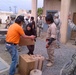 Role players help distribute humanitarian aid to the local populace as U.S. Marines from 1st Civil Affairs Group (CAG) and Soldiers from 416th CA Bn. (Abn.) provide security.