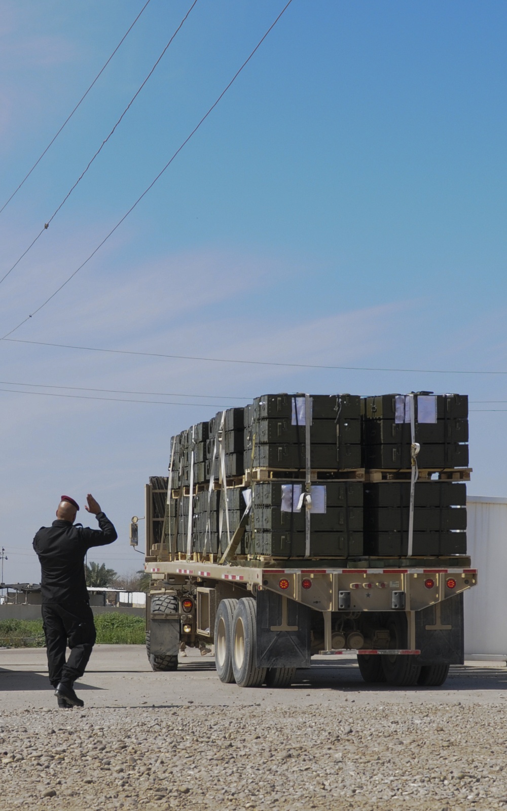 Iraqi Soldier helps US Soldier park truck of ITEF supplies