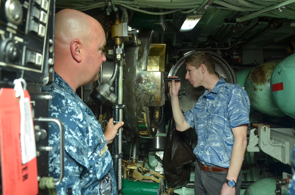 Will Rogers, a military legislative assistant, looks through a periscope on board USS Topeka during a Congressional delegation tour