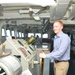 Alec Johnson, a military legislative assistant, poses with the helm of USS Frank Cable (AS 40) during a Congressional tour