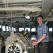 Will Rogers, a military legislative assistant, poses with the helm of USS Frank Cable (AS 40) during a Congressional tour