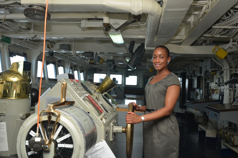 Maj. Marshalee Clarke, a Congressional liaison, poses with the helm of USS Frank Cable (AS 40) during a Congressional tour