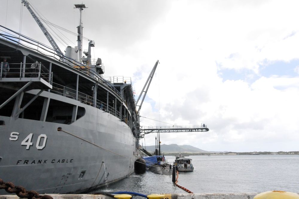 USS Frank Cable conducts maintenance on USS Topeka in port Polaris Point, Guam.
