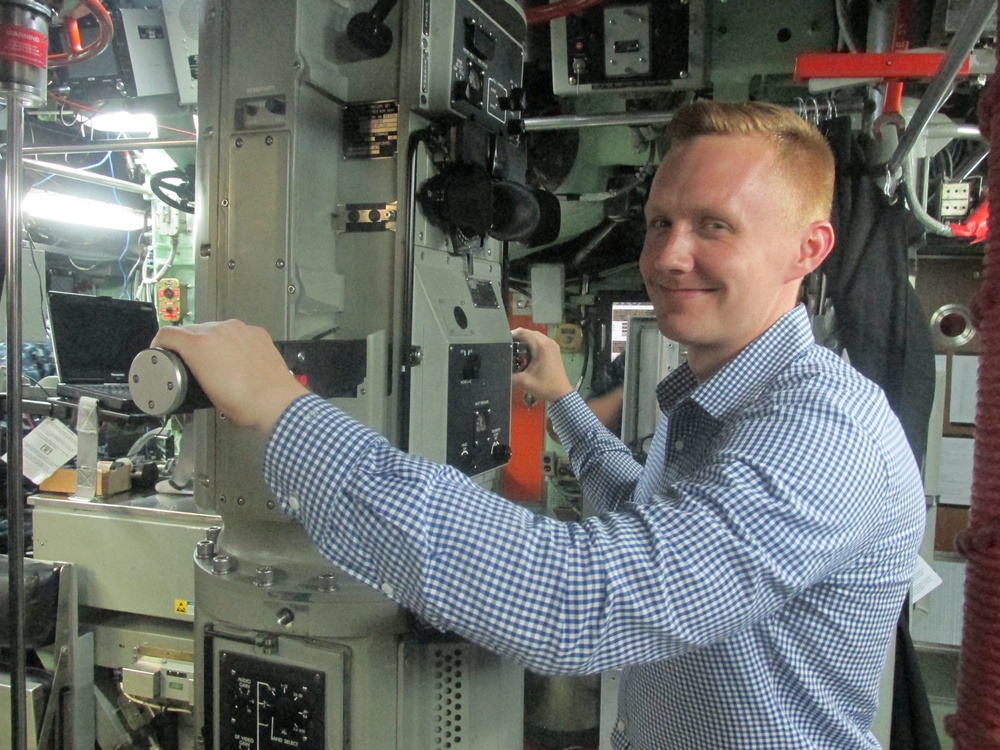 Alec Johnson, a military legislative assistant, looks through the periscope of USS Topeka during a Congressional delegation tour
