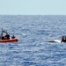 A small boat crew from the U.S. Coast Guard Cutter Bernard Webber approaches 10 people on top of an overturned vessel April 9, 2016.