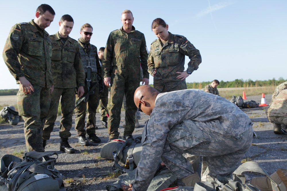 U.S. Army A Sgt. First Class assists German paratroopers